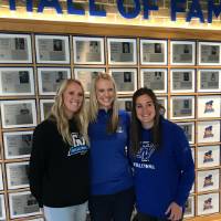 3 attendees pose for a picture infront of the hall of fame